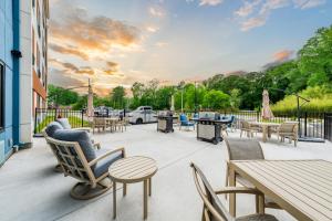 a patio with tables and chairs and a grill at YourSpace Hotels Chesapeake in Chesapeake