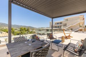 a table and chairs on a patio with a view at Illumi's Hotel in Villasimius