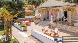 ein Haus mit einer Terrasse mit Stühlen und einem Tisch in der Unterkunft Orientem Villa - Sea View Near Zante Town in Argassi