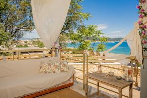 ein Bett und ein Tisch mit Blick auf das Meer in der Unterkunft Orientem Villa - Sea View Near Zante Town in Argassi