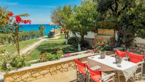 eine Terrasse mit Tisch und Stühlen und dem Meer in der Unterkunft Orientem Villa - Sea View Near Zante Town in Argassi + 27 Fotos