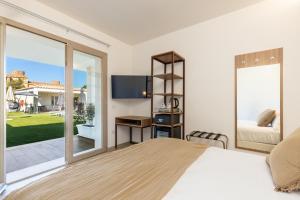a bedroom with a bed and a sliding glass door at Illumi's Hotel in Villasimius