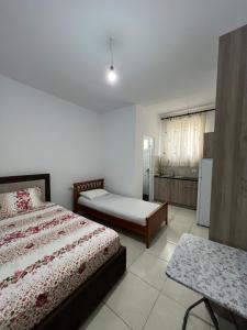 a bedroom with two beds and a table in it at Grandma's in Sarandë
