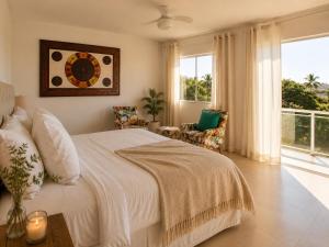 a bedroom with a bed and a large window at casa amplia y luminosa en porto da barra in Búzios