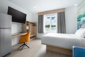 a hotel room with a bed and a window at YourSpace Hotels Chesapeake in Chesapeake