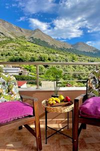 a table with a bowl of fruit on a balcony at Theros Lux Apartment in Émbonas