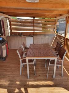 a wooden table and chairs on a deck at Mobile Home MEDITERRA in Pirovac +10 photos