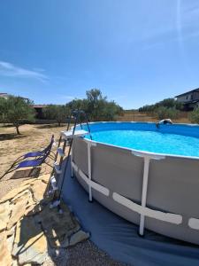 a small boat sitting next to a swimming pool at Mobile Home MEDITERRA in Pirovac