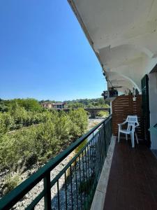a balcony with two chairs and a view of a river at B&B Giù di sotto in Gavi