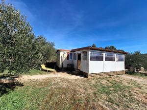 a small house in a field with trees at Mobile Home MEDITERRA in Pirovac