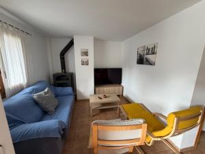 ein Wohnzimmer mit einem blauen Sofa und einem Tisch in der Unterkunft Escuacho in Escarrilla