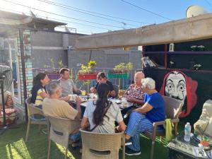 a group of people sitting around a table on a patio at Castle hostel in Cairo