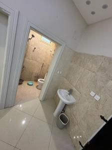 a bathroom with a toilet and a sink at شاليه إطلالة in Buraydah