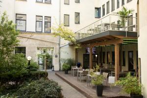 an outdoor patio with tables and chairs in front of a building at acama Hotel & Hostel Kreuzberg in Berlin