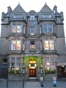 a large brick building with a large window at The Stromness Hotel by Paymán Club in Stromness