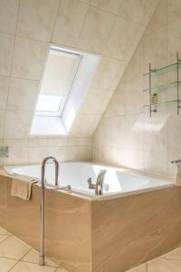ein Badezimmer mit Badewanne mit Oberlicht in der Unterkunft Hotel Augusta Am Kurfürstendamm in Berlin + 48 Fotos