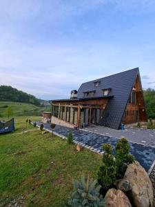 a house with a metal roof on a hill at Cabana 3 Stejari Maramureș in Călineşti
