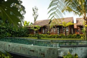 a resort with a pool in front of a building at ChannaS villas in Payangan