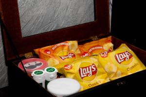 a wooden box filled with chips and snacks at Brick House Hotel Lahore in Lahore