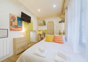 a bedroom with a white bed with two pillows at Studio Welcome, petit espace, grand confort in Arudy