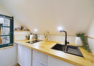 a kitchen with a sink and wooden counter top at Studio Welcome, petit espace, grand confort in Arudy