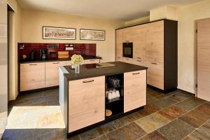 a large kitchen with wooden cabinets and a counter at Wohnen am Weingut - Über den Fässern in Briedel