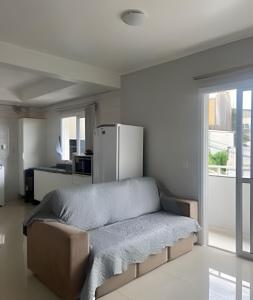 a bed in a room with a refrigerator at Apartamento - 2 Quartos * Completo * Central in Bento Gonçalves