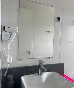 a bathroom with a sink and a hair dryer at Apartamento - 2 Quartos * Completo * Central in Bento Gonçalves +22 photos