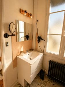 a bathroom with a white sink and a mirror at La Cour Du Puits, Chambre Darjeeling in Cormeilles +5 photos