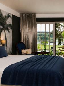 a bedroom with a large bed and a large window at Hotel Villa Rainer in Pörtschach am Wörthersee