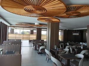 a restaurant with wooden ceilings and tables and chairs at Borbon Hotel & Restaurant in Jowai