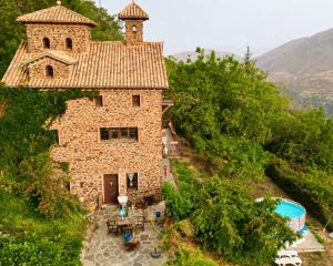 an external view of a stone house with a pool at Las Casas del Nogal - Guesthouse en Sierra Nevada in Güéjar-Sierra +30 photos