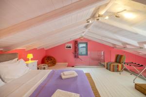 a large room with a bed and pink walls at Villa Kirki Apartments in Agia Effimia