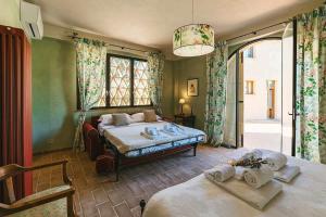 a bedroom with two beds and a large window at La Pimpinella di Semifonte in San Donnino