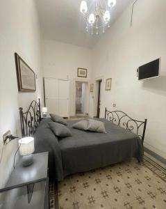 a bedroom with a large bed and a chandelier at Le Cascine in Pisa