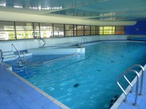 a large swimming pool with blue water in a building at Lune Meadow in Kirkby Lonsdale