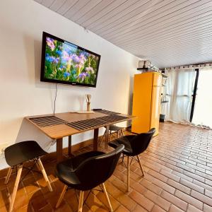 a dining room table with a television on the wall at Cobertura Mangabeiras com vista incrível de BH e área gourmet in Belo Horizonte +26 photos