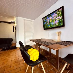 a dining room with a table and a tv on the wall at Cobertura Mangabeiras com vista incrível de BH e área gourmet in Belo Horizonte