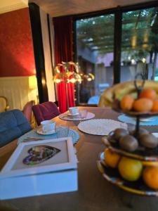 a table with plates of fruit on top of it at La Cour Du Puits, Chambre Darjeeling in Cormeilles