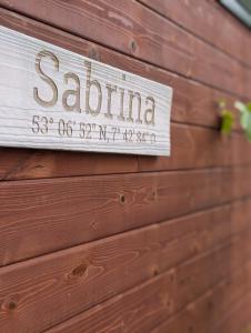 a sign on the side of a wooden wall at Tinyhouse Sabrina in Papenburg