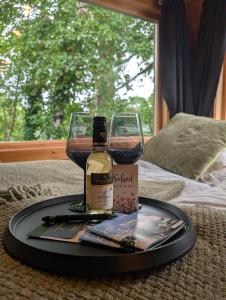 a tray with a bottle of wine and a glass at Tinyhouse Sabrina in Papenburg
