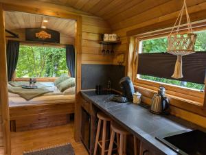 a kitchen in a log cabin with a bed at Tinyhouse Sabrina in Papenburg +4 photos