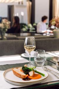 a plate of food and a glass of wine on a table at Mandarin Oriental, Prague in Prague