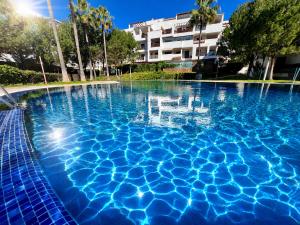 a swimming pool with blue water in front of a building at La Cala Center Premium Penthouse Motorized Terrace & Sea Views in La Cala de Mijas