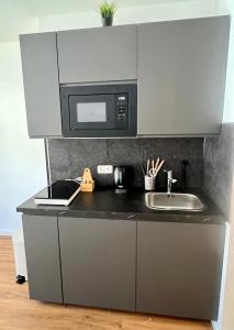 a kitchen with a sink and a microwave at Apartment Altstadt Stralsund in Stralsund