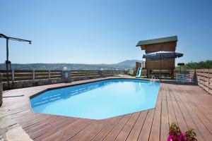 a swimming pool on a wooden deck with a gazebo at Peaceful house in Goúrnes