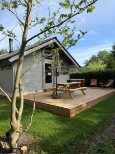 a house with a wooden deck with a picnic table at Chalet Olive in Durbuy