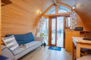 a living room with a couch and a large window at Hausboot Captain Hook in Stralsund
