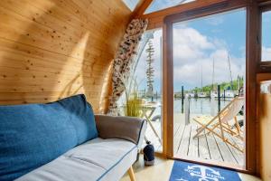 a living room with a couch and a large window at Hausboot Captain Hook in Stralsund