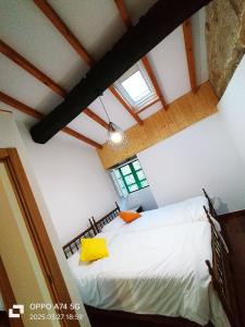 a bedroom with a white bed and a window at Muiño Verde in Loña del Monte